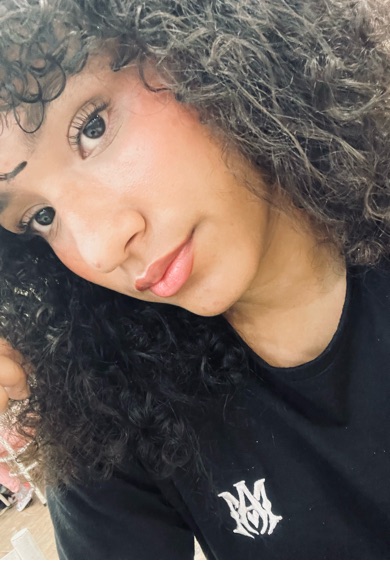 Woman with curly hair smiling into the camera