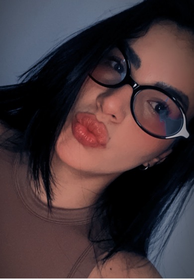 Woman wearing glasses, mid-sentence on a video call